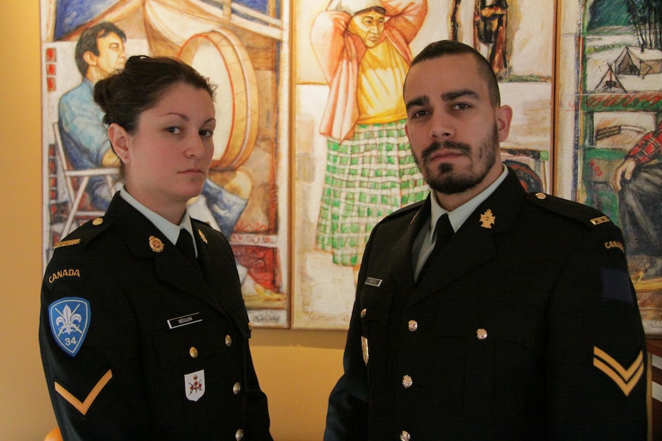 Deux militaires posent en tenue face à la caméra.