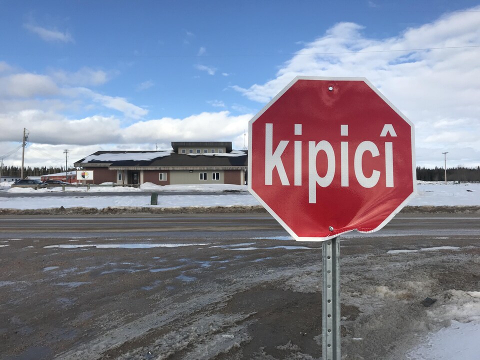 Un panneau d'arrêt sur lequel il est écrit « kipicî », devant une route dans une communauté autochtone du Manitoba.