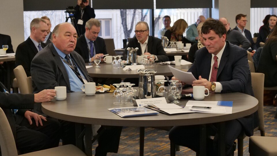 Les deux hommes à une table lors du symposium à Calgary.
