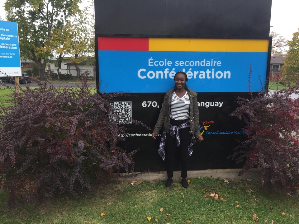 Photo de Liberasse devant le panneau de l'école