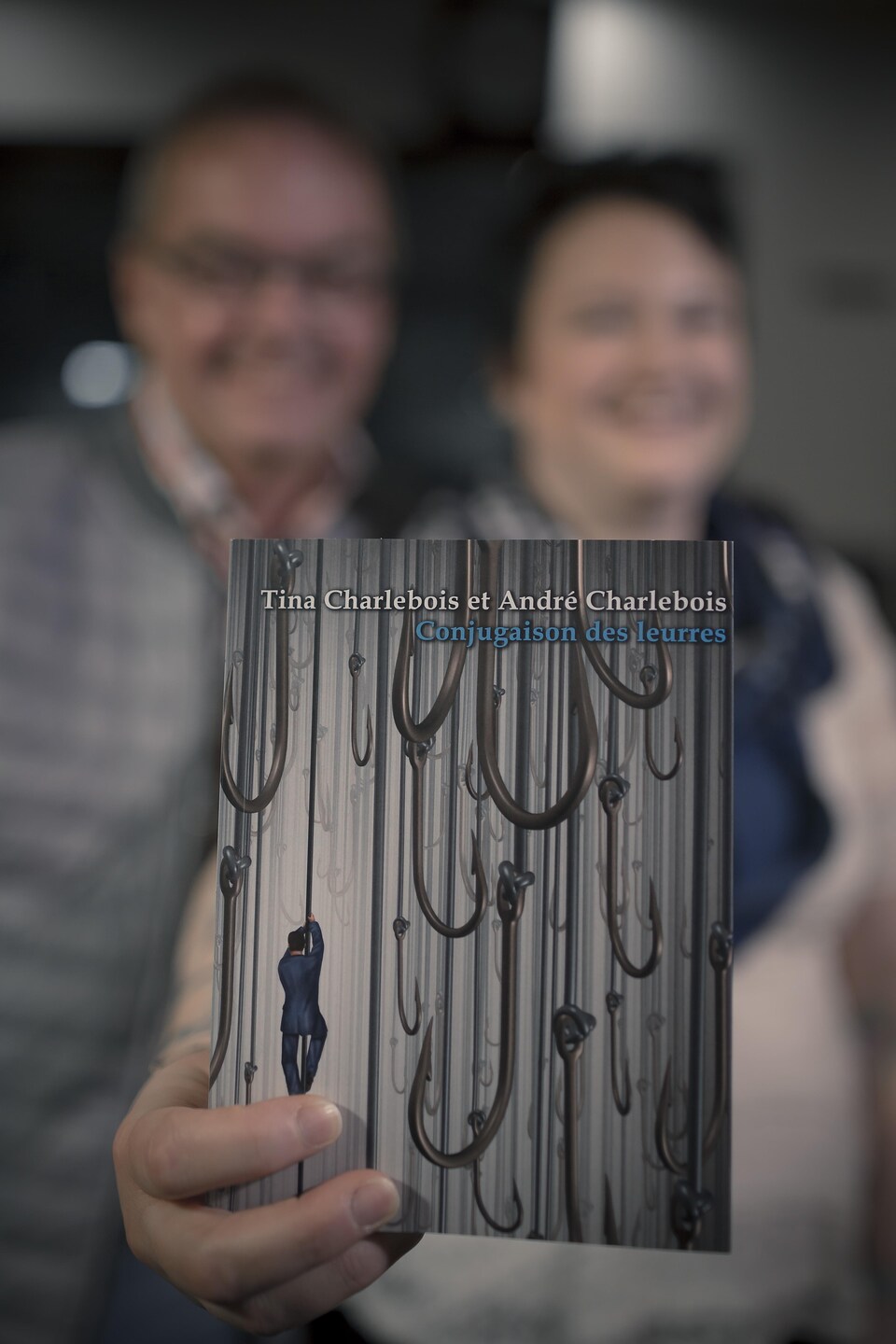 Tina et André Charlebois tiennent un exemplaire de leur livre commun intitulé « Conjugaison des leurres ».