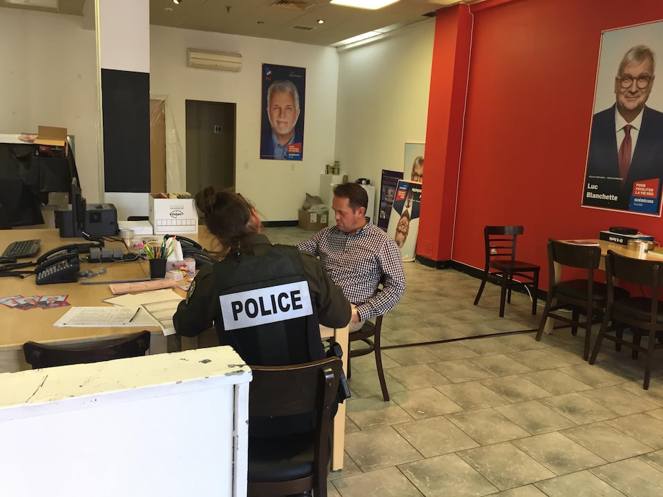Une policière écoute la déposition d'un membre de l'équipe de Luc Blanchette.