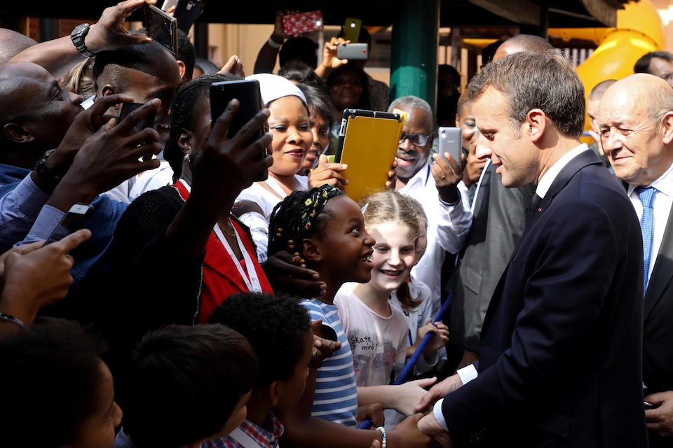 Emmanuel Macron conducts a walkabout in Nigeria.  A little girl took his hands and looked up at him with admiration.