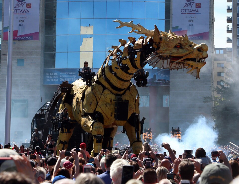 Le dragon géant derrière des milliers de personnes qui photographient La Machine.