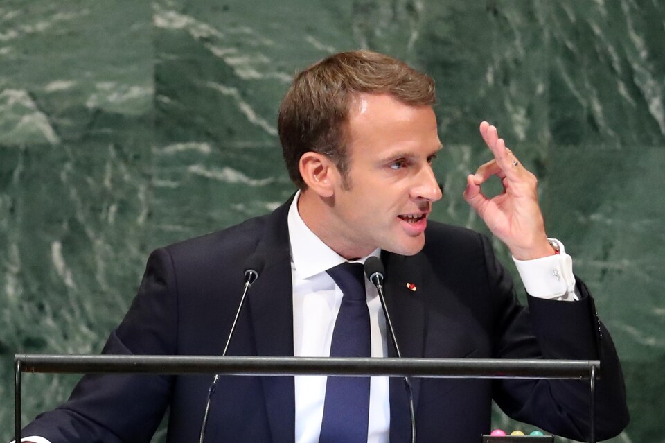 Le président français, Emmanuel Macron, la main en l'air