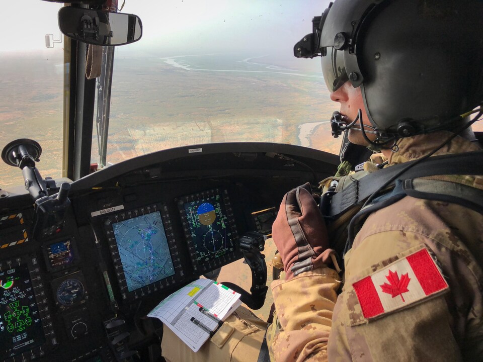 Dans le cockpit, le major Dominique Simard aux commandes d'un Chinook, en plein vol au dessus du Mali.