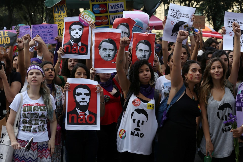 Des manifestantes, certaines le poing levé, d'autres avec des affiches anti-Bolsonaro.