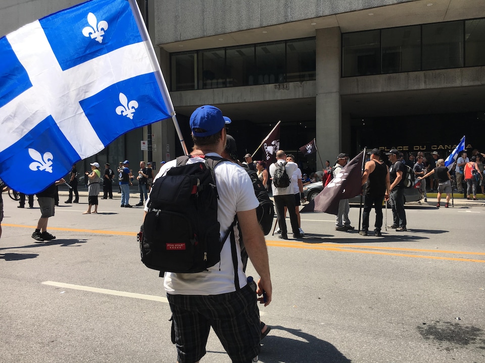 Des membres du groupe Independance Day ont brandi des drapeaux du Québec à la Place du Canada devant les bureaux d’immigration pour dénoncer « l’immigration illégale » au Canada. 