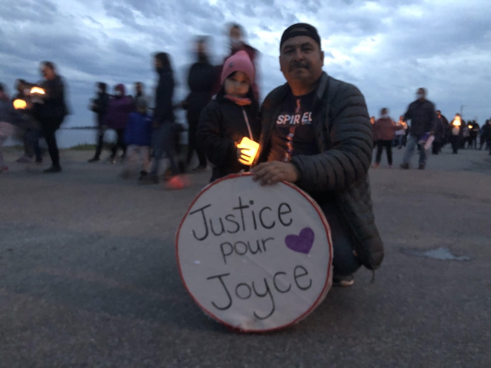 Un homme et une petite fille avec un cercle de tissu où l'on peut lire "Justice pour Joyce"