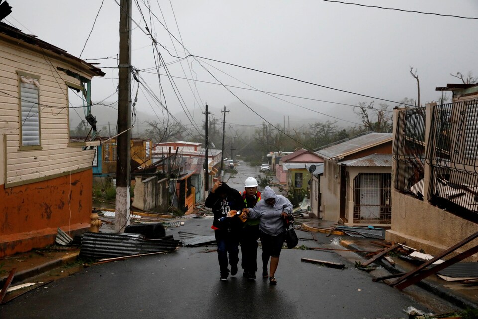 Un secouriste aide deux personnes après le passage de l'ouragan Maria à Guayama, Porto Rico.