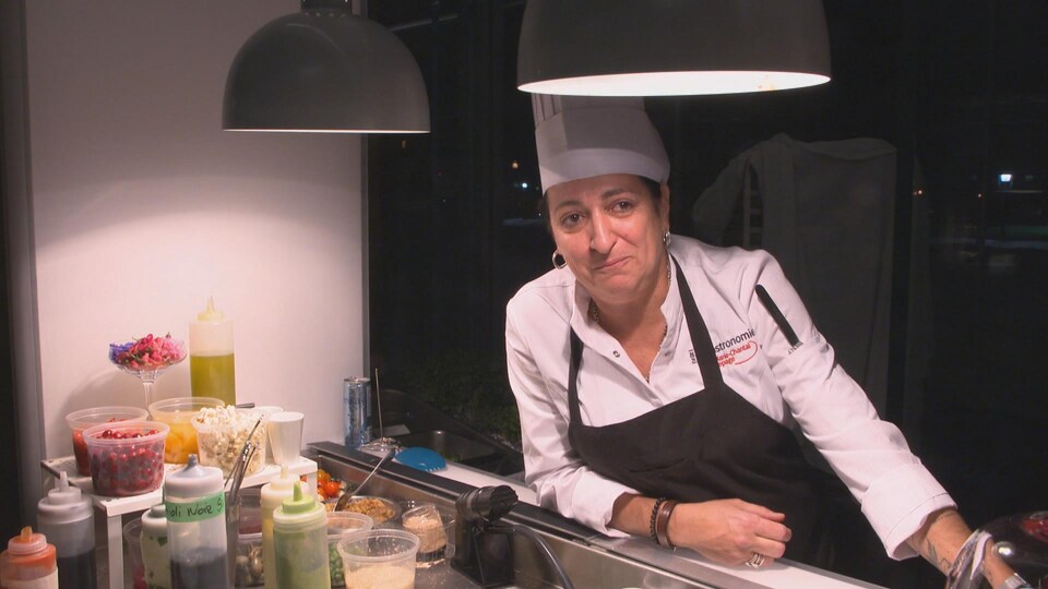 On voit Mme Lepage à la cuisine de son restaurant, en train de parler à la caméra.