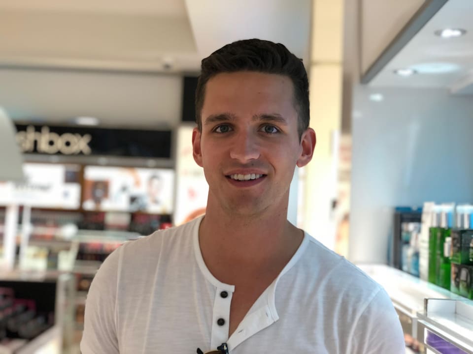 Un jeune homme dans un magasin de produits cosmétiques.