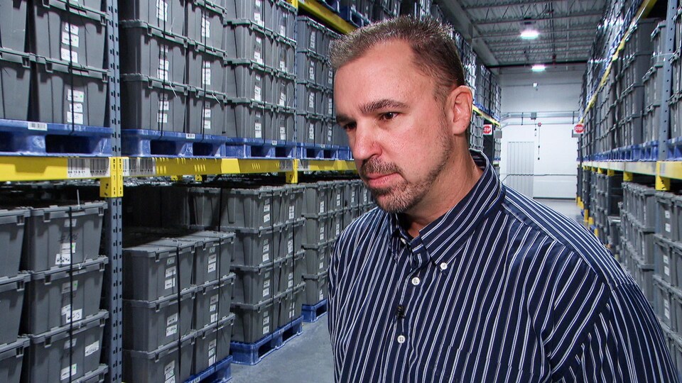 M. Sly en entrevue dans un entrepôt.