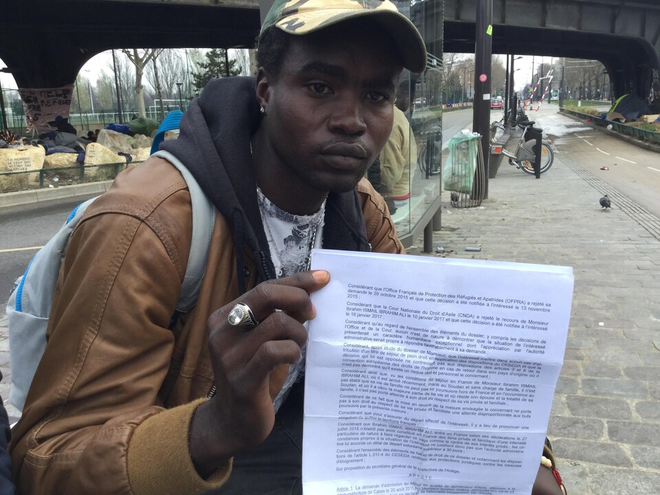 Un migrant montre l'une de ses lettres.