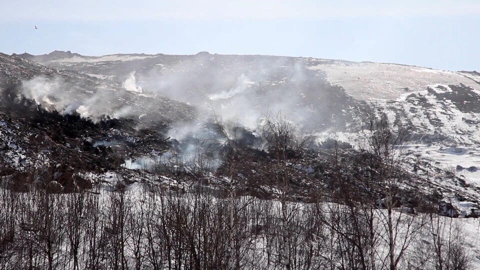 De la fumée se dégage de montagnes de déchets empilés sur une plaine enneigée en banlieue de Moscou.