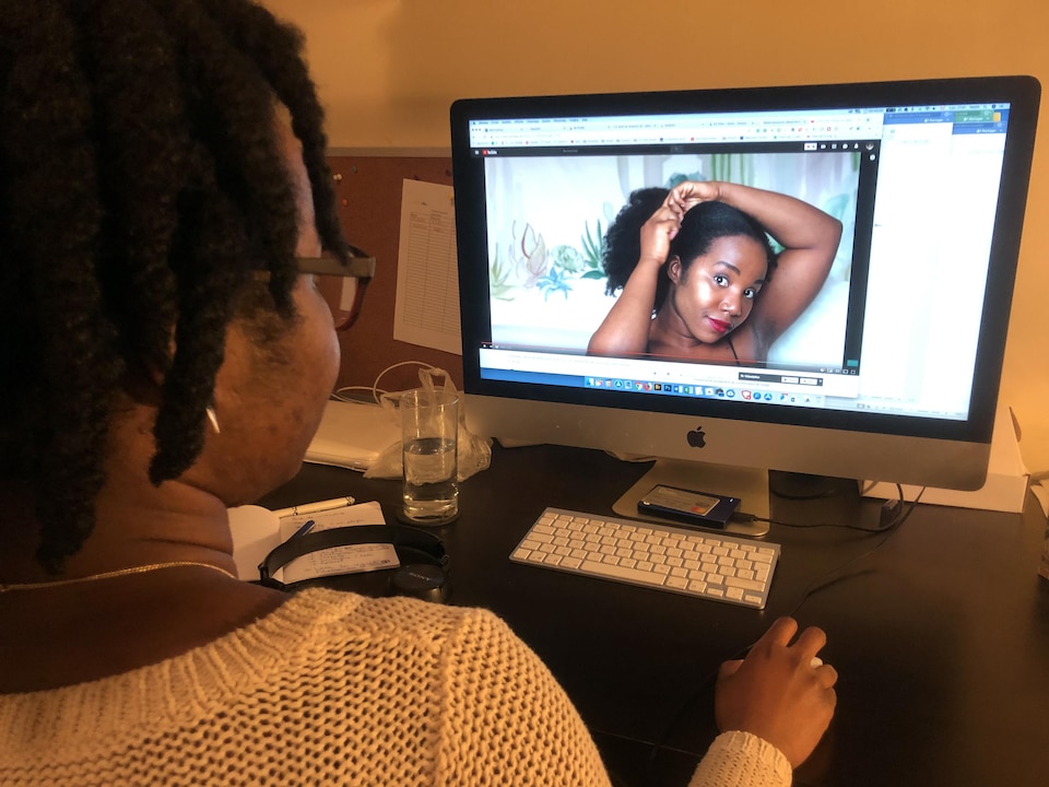 Esther Nelsa, alias Nel, regarde l'une des vidéos de son blogue Racines Crépues. Elle est l'une des premières à avoir documenté son retour au cheveu au naturel au Québec.