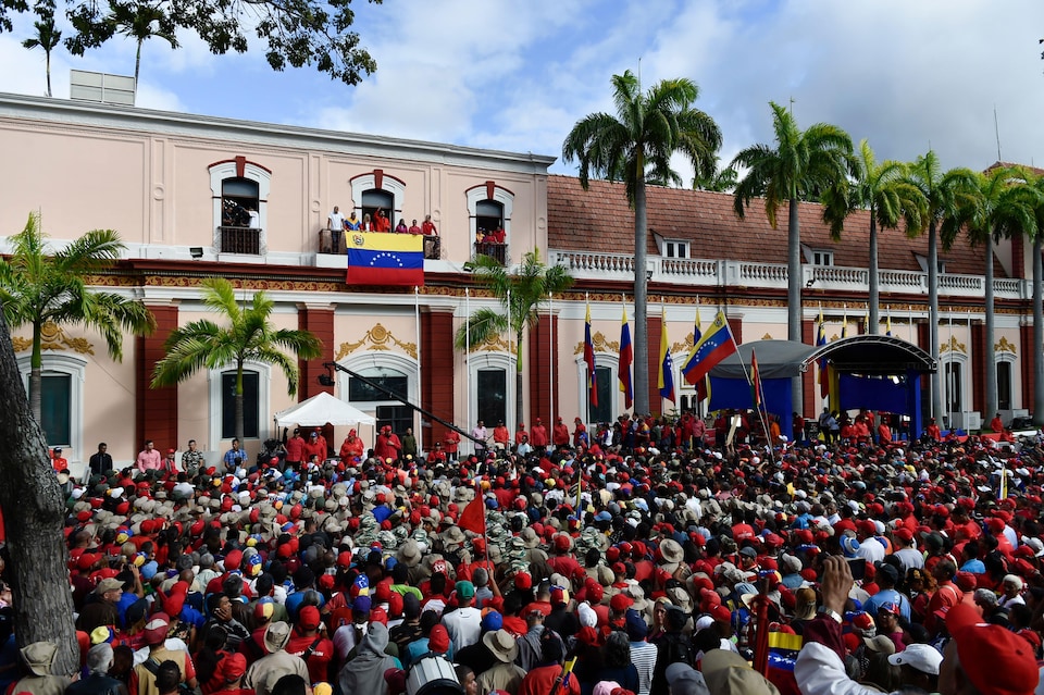 Des centaines de personnes vêtues de rouge écoutent le président Maduro.