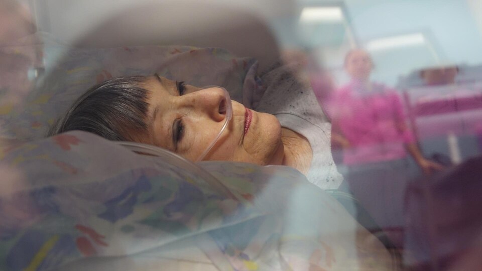 Nicole Brodeur en train de suivre un traitement d'oxygénothérapie sous le regard de la kinésiologue Geneviève Brodeur