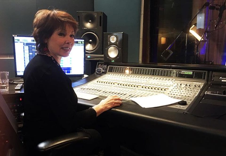 Nicole Martin est devant une console de son, dans un studio.