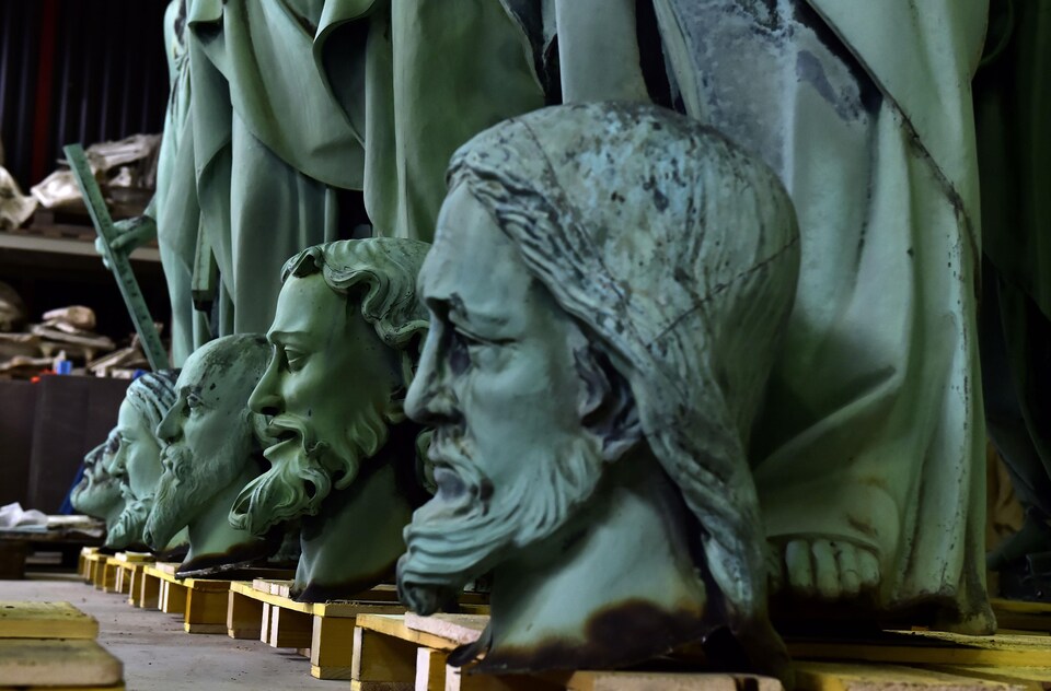 Gros plan sur certaines des têtes des statues, aux pieds des statuaires des apôtres et évangélistes.