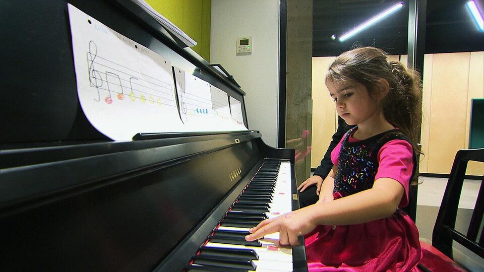Une élève de l'école primaire St-Rémi, dans l'arrondissement de Montréal-Nord, joue du piano.