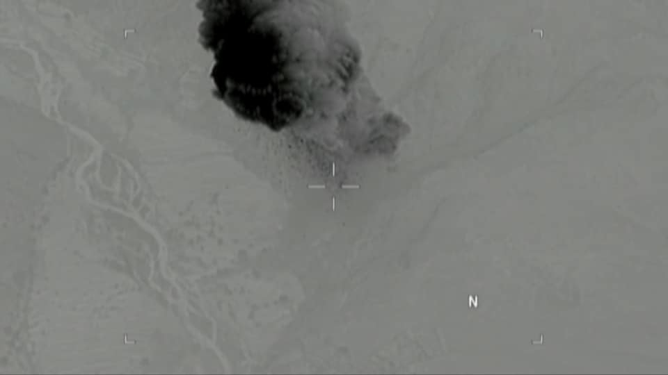 Une image tirée de la vidéo publiée par l'armée américaine, qui montre un panache de fumée s'élevant d'un terrain accidenté.