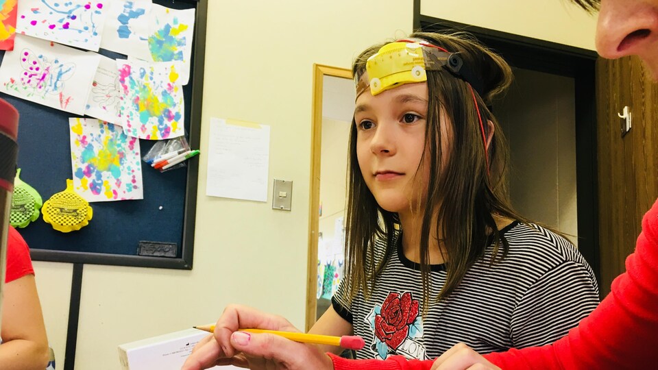 Fillette portant un casque avec des électrodes et des fils.