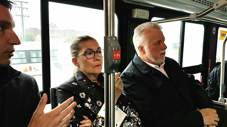 Dans un autobus, Philippe Couillard et sa conjointe.