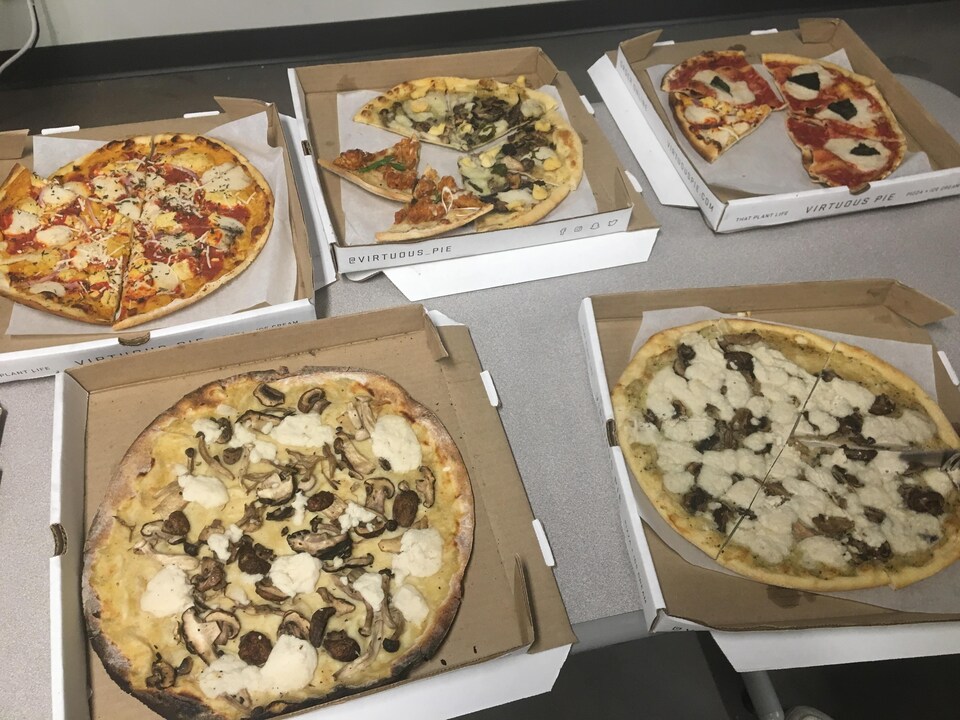 Des pizzas coupées en pointes dans des boîtes en carton.