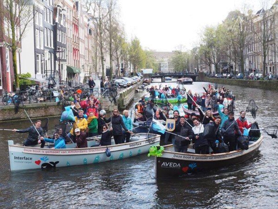Des touristes sont dans des embarcations pour repêcher les déchets en plastique qui flottent sur les canaux d'Amsterdam. 
