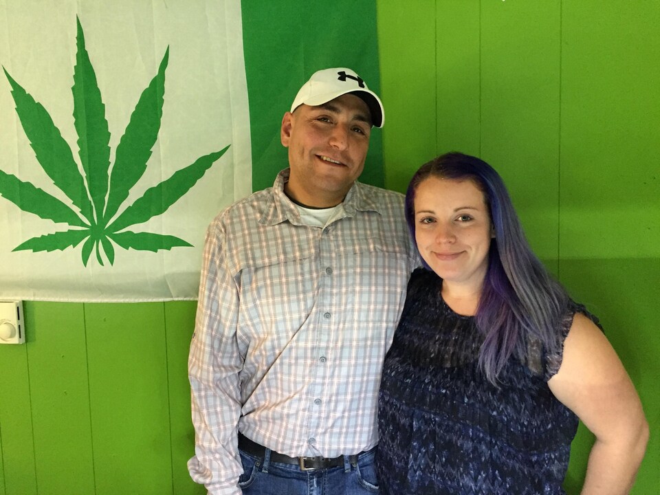 Le couple pose devant un drapeau avec un signe de cannabis.