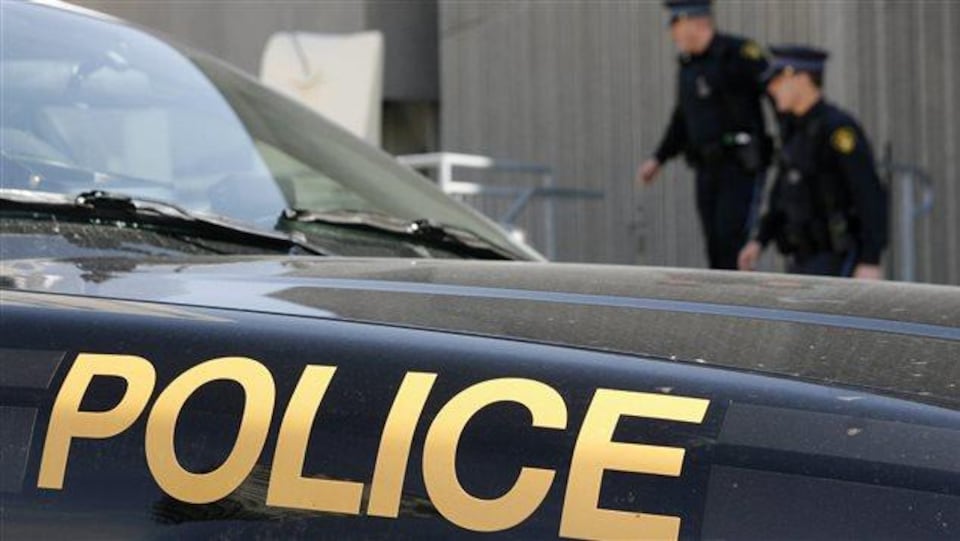 Deux agents de la police provinciale de l'Ontario derrière une autopatrouille.