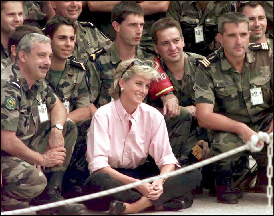 La princesse souriante en compagnie de soldats français à l'aéroport de Sarajevo en août 1997.