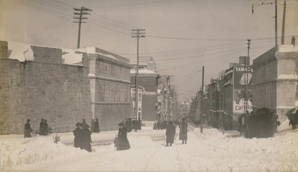 Des passants près de la rue Saint-Jean, dont la porte avait été enlevée pour laisser passer le tramway électrique, en 1897