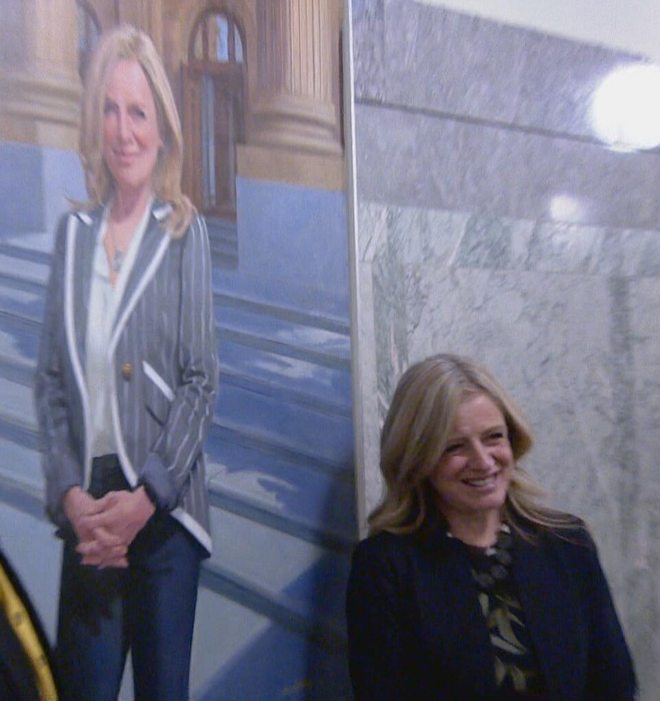 Rachel Notley, pose devant son portrait accroché à l'Assemblée législative de l'Alberta.