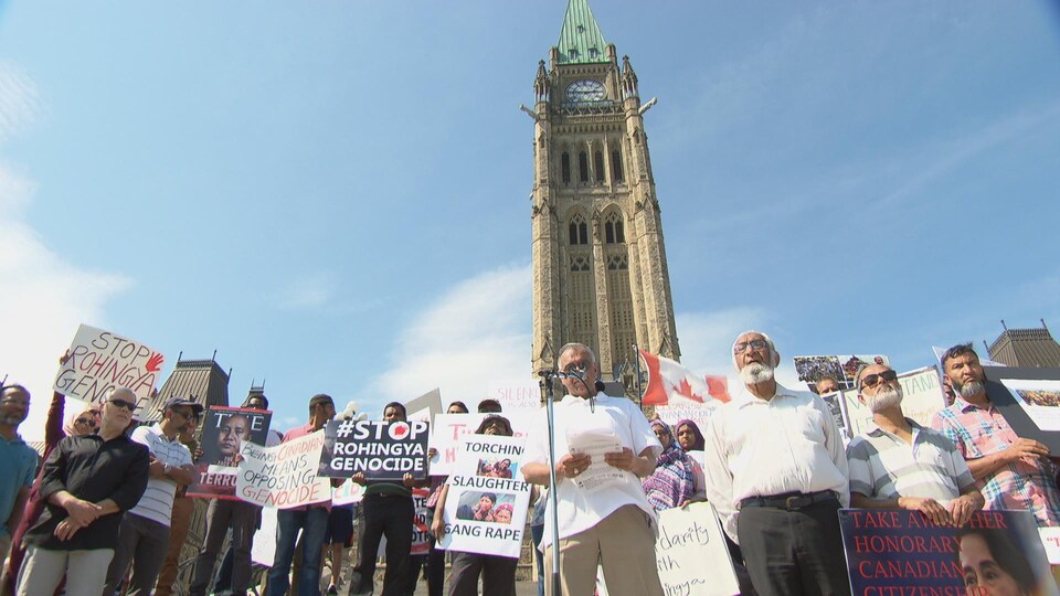 Un groupe de manifestants devant la tour de la Paix, sur la colline du Parlement, à Ottawa.