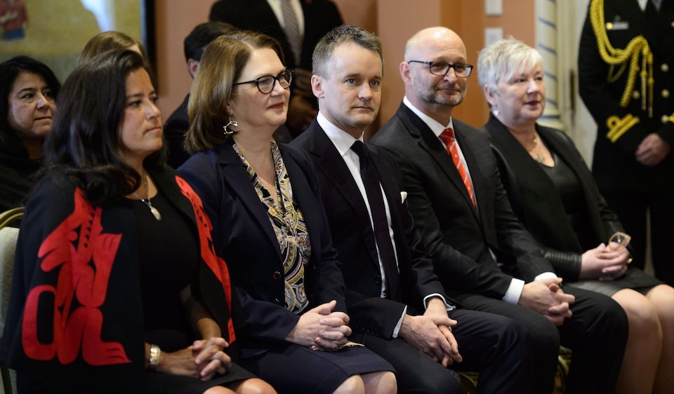 Jody Wilson-Raybould, Jane Philpott, Seamus O'Regan, David Lametti et Bernadette Jordan sont assis côte-à-côte dans une salle de la résidence de la gouverneure générale. 