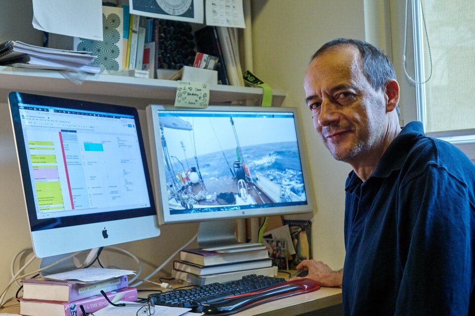 Roberto Casati, souriant, assis devant son ordinateur.              