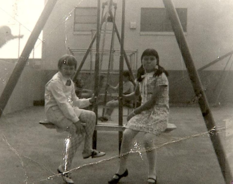 Photo en noir et blanc de deux jeunes filles autochtones dans une salle de jeu.