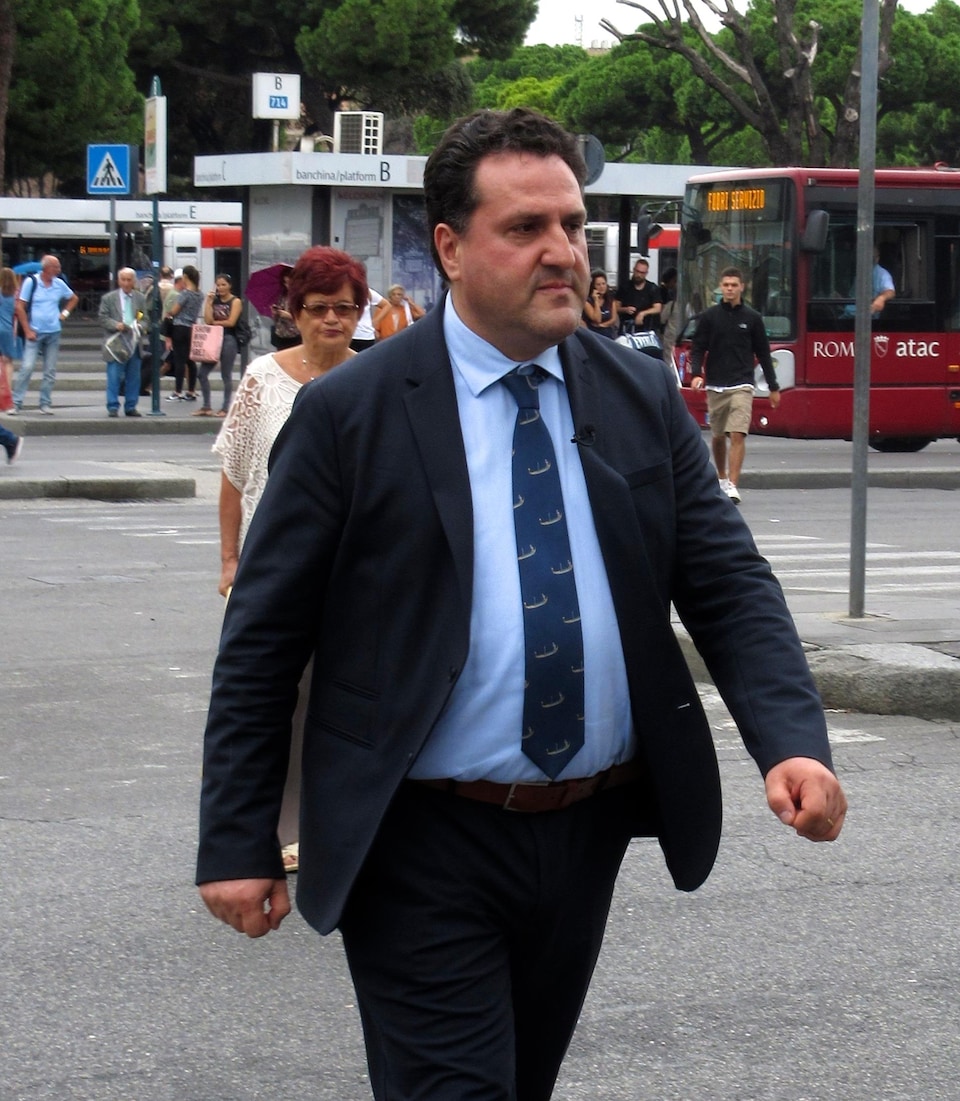 On voit Saverio de Bonis en train de marcher dans une rue de Rome, en Italie.