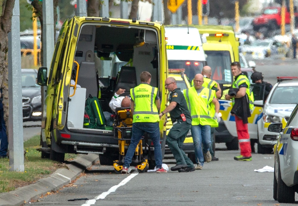 Des ambulanciers montent une civière dans une ambulance.