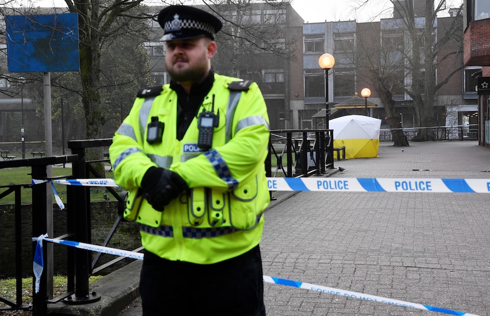 Un policier britannique, debout devant la scène de crime, qui a été scellée.