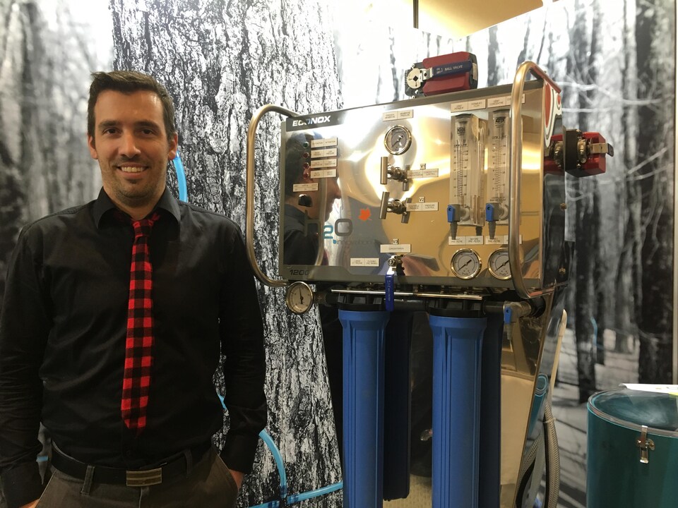Mathieu Fortier, directeur des ventes en érablières chez H2O Innovation, debout devant un appareil.