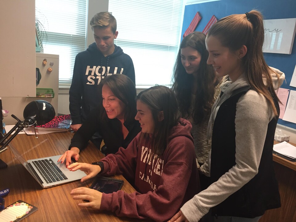 La Coordonnatrice du programme d'immersion du district scolaire 22 en Colombie-Britannique, Stéphanie Hewson, discute devant un ordinateur avec des élèves du secondaire à l'École W.L.Seaton de Vernon. 