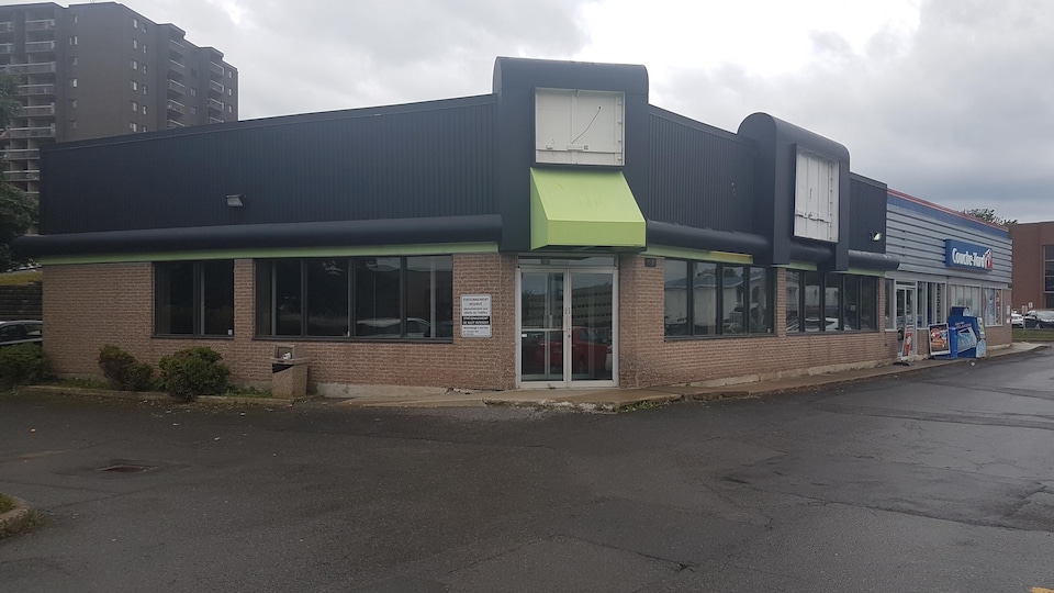 Photographie d’un espace commercial vacant situé au 2491, chemin Sainte-Foy, à Québec. Le local est situé à côté d’un dépanneur de l'enseigne Couche-Tard.