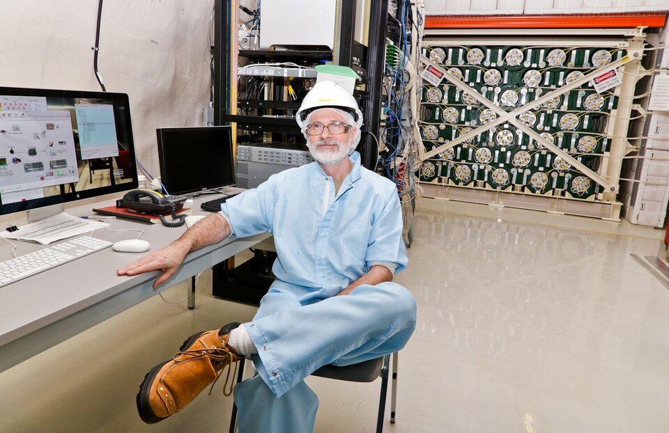 Le physicien Clarence Virtue dans le laboratoire souterrain du SNOLAB, devant le détecteur de neutrinos HALO