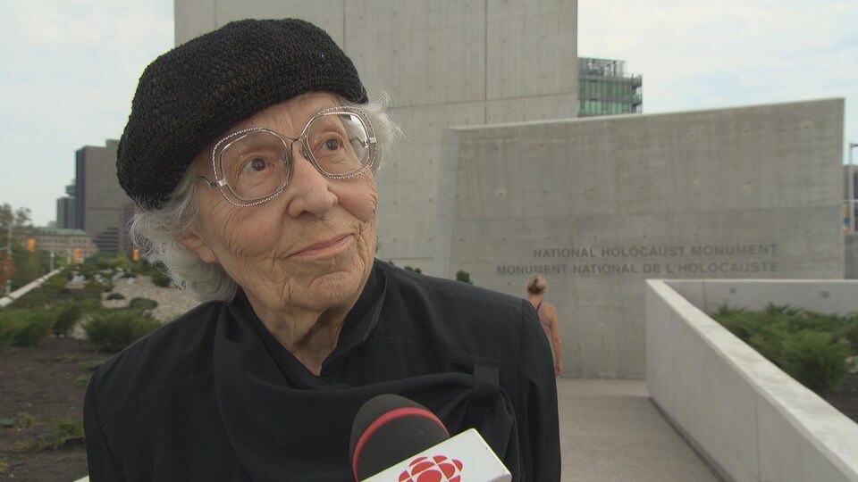 Une dame âgée devant le Monument national de l'Holocauste à Ottawa