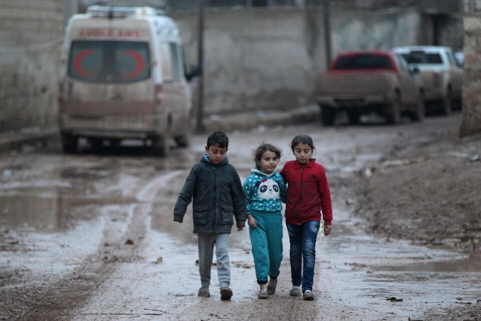 Trois enfants se promènent dans la ville d'Al-Rai, dans la province d'Alep.