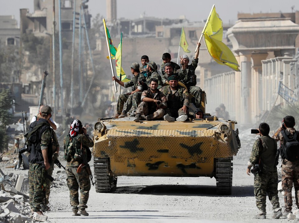 Des combattants des Forces démocratiques syriennes célèbrent leur reprise de Raqqa des mains du groupe armé État islamique.