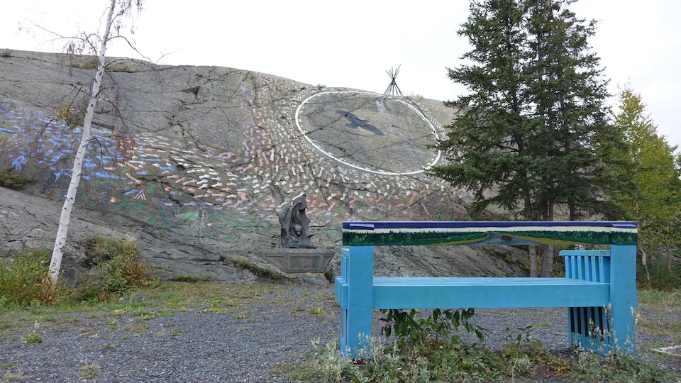 parc avec murale sur un rocher présentant des empreintes de mains